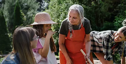Personas haciendo jardinería juntas en un lujoso jardín de comunidad