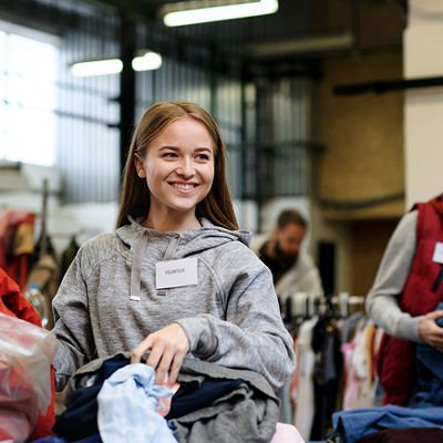 Mujer ayudando en una campaña benéfica de recolección de ropa