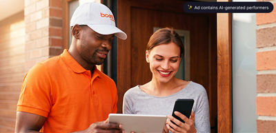 A Boost Mobile delivery driver helping a smiling customer set up a new smartphone at her door.